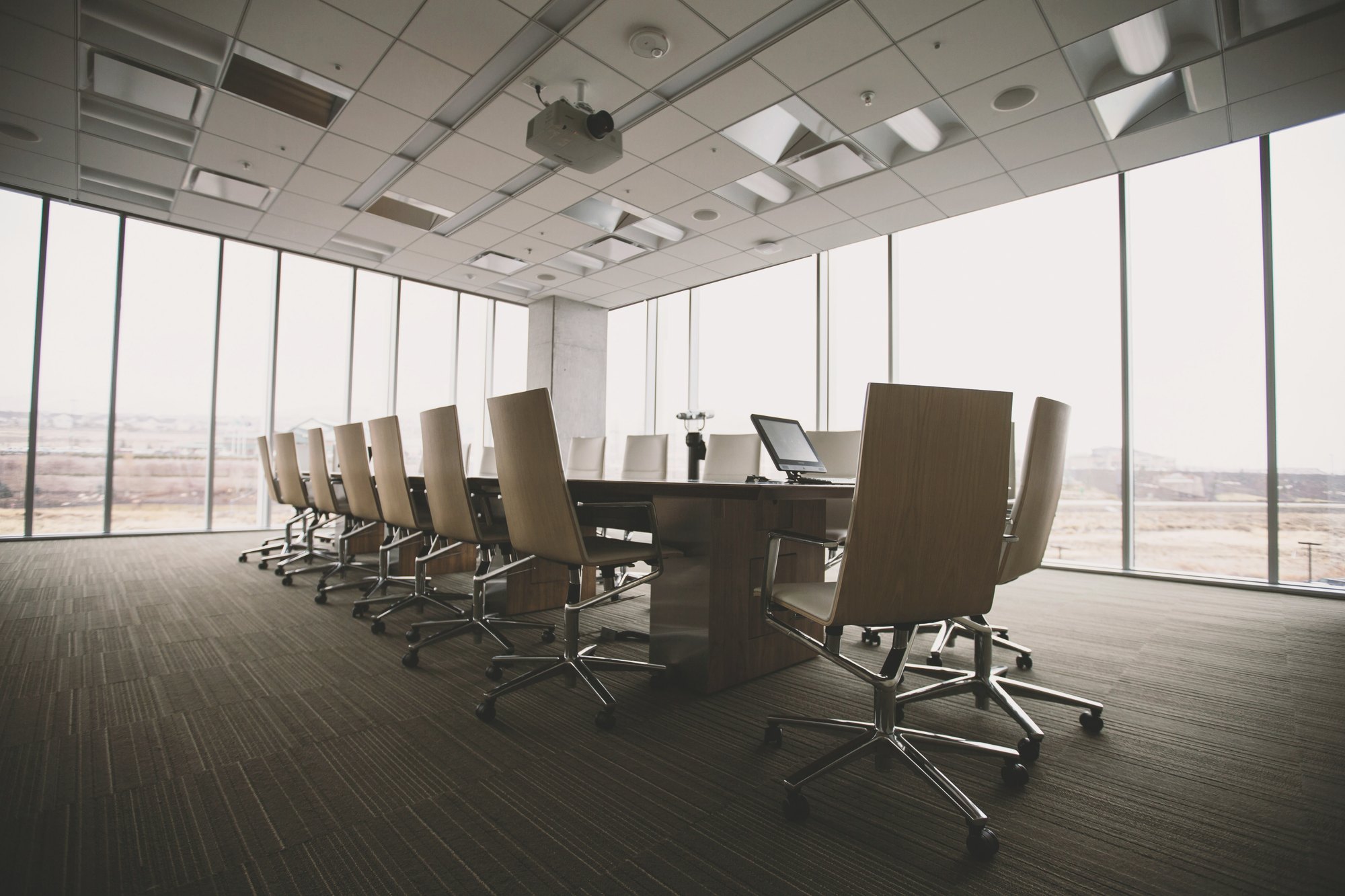 Executive boardroom with wood chairs and floor-to-ceiling windows